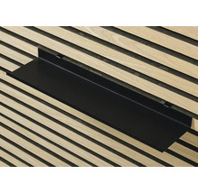 Svart vägghylla framför trävägg