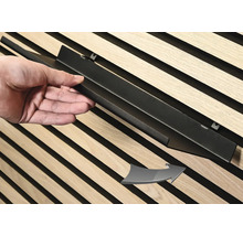 Montering av en svart metallist på en väggpanel