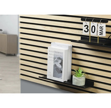 Väggpanel av trä med hyllor, bok, växt och kalender