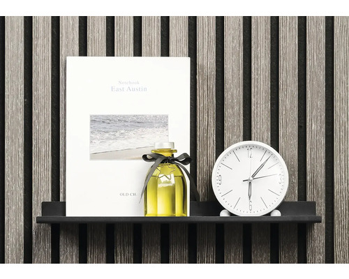 Dekorativ scen med anteckningsbok, doftflaska och klocka på en hylla