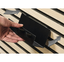 Närbild av en person som fäster en hylla på en träribbvägg