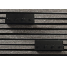 Två grå väggpaneler med fyra svarta krokar