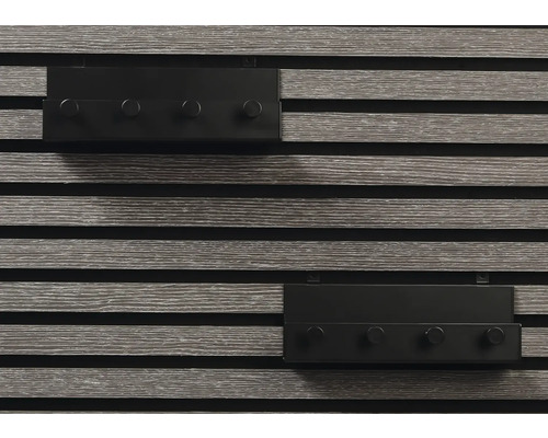 Två grå väggpaneler med fyra svarta krokar