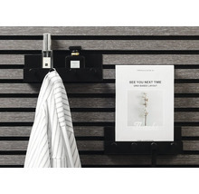 Svart vägghylla med jacka, parfym och A4-papper