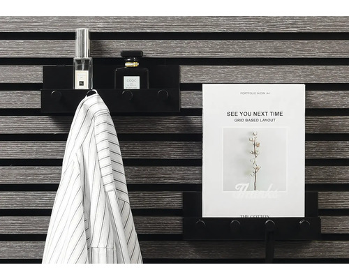 Svart vägghylla med jacka, parfym och A4-papper