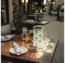 Dekorativ solarlampa på ett bord utomhus.