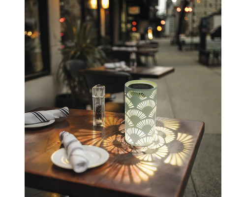 Dekorativ solarlampa på ett bord utomhus.