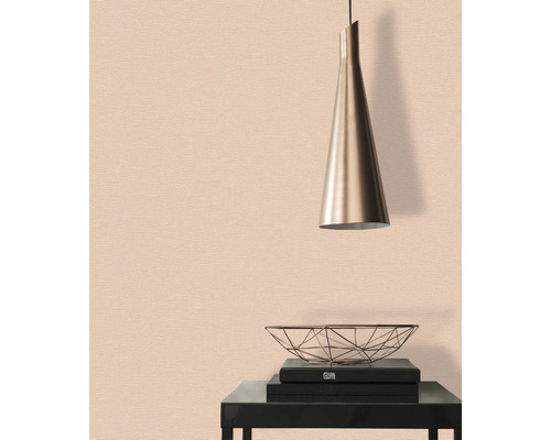 Närbild av en subtil tapet med en hängande lampa och dekorativa element på ett bord