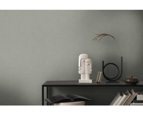 Dekorativt arrangemang på en svart hylla med skulptur och vas