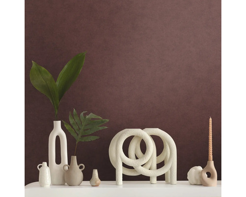 Dekorativt arrangemang med vaser, ljusstake och dekorativt föremål på en hylla.