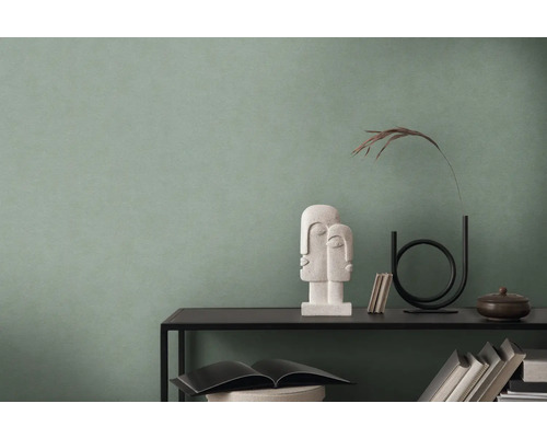 Mysigt rum med grön vägg, dekorerat med skulptur och tillbehör på en hylla.