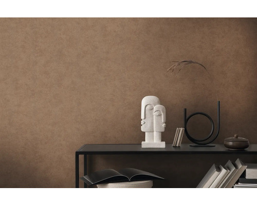 Väggdekoration med brun strukturtapet och dekorativa element på en hylla.