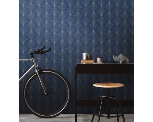 Rumsutsikt med blå mönstrad tapet, skrivbord, cykel och pall