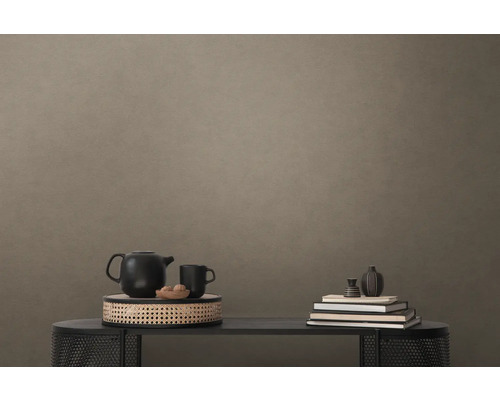 Dekorativ scen med tekanna, kopp, skål och böcker på ett bord