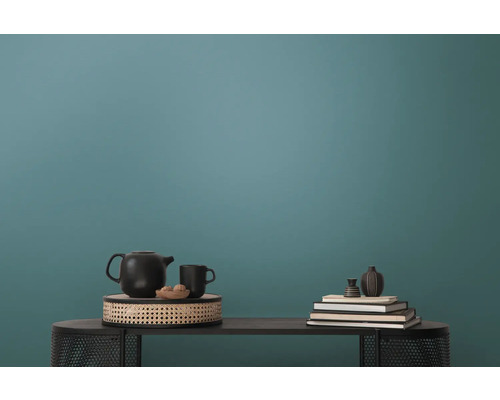 Dekorativ scen med tekanna, kopp, böcker och vaser på ett bord