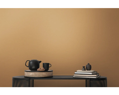 Dekorativ arrangemang med tekanna, kopp, böcker och vaser på ett bord