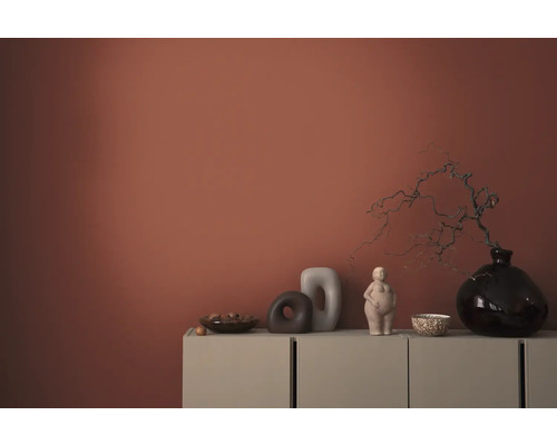 Dekorativa föremål på ett skåp framför en vägg