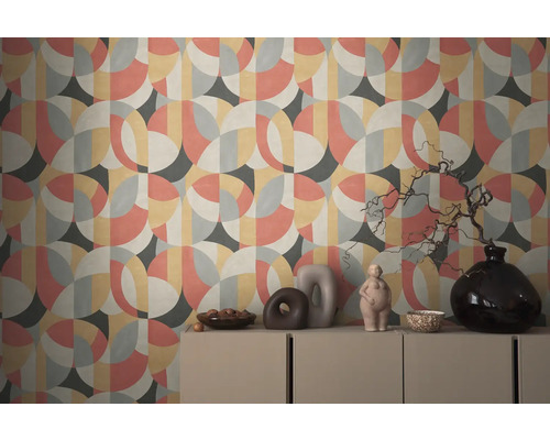 Vägg med geometrisk tapet och dekorativa föremål på ett skåp