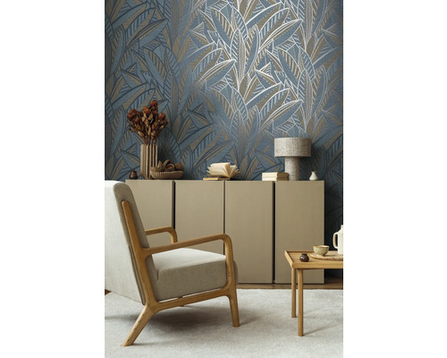 Vardagsrum med mönstrad tapet med bladmönster, fåtölj, byrå och bord