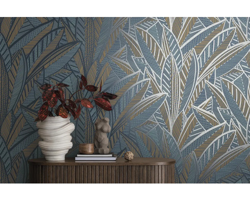 Dekorativ tapet med abstrakt bladmönster och matchande dekorativa föremål på ett bord