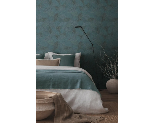 Sovrum med mönstrade tapeter, säng och golvlampa