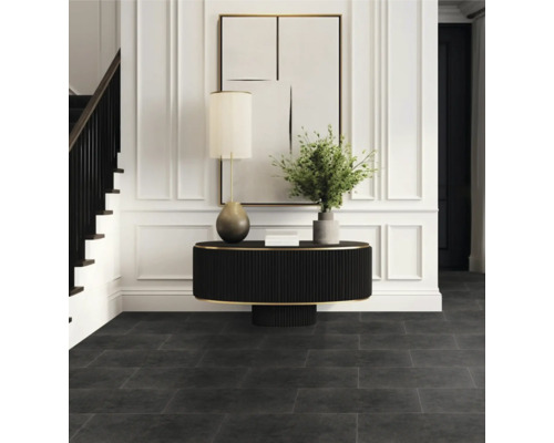 Entré med mörkt golv, bord, lampa och trappa