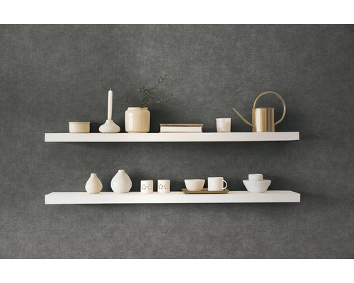 Två vita vägghyllor med dekorativa föremål på en mörk vägg