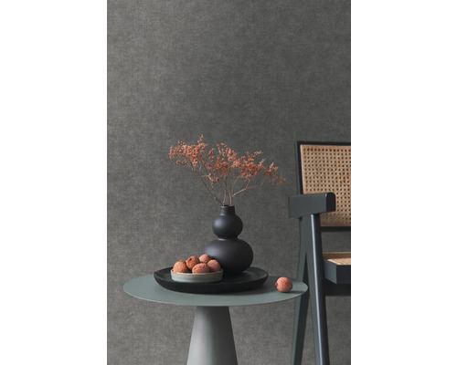 Närbild av ett bord med dekoration framför en mörk väggtapet.