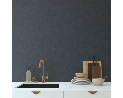 Diskho med kran, disk, skärbrädor och diskmedel på en köksbänk framför en vägg