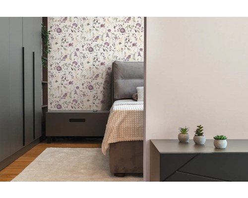 Sovrum med säng, sängbord, garderob och blomstertapet