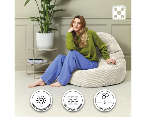 Kvinna sitter på en beige sittsäck i vardagsrummet