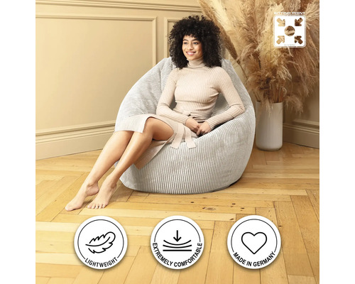 Kvinna sitter i en ljusfärgad, ribbad sittpuff i manchester.