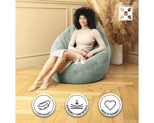 Kvinna sitter i ett ljust rum på en grön sittsäck