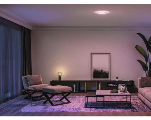 Modernt vardagsrum med taklampa, sittmöbler och dekorationer.