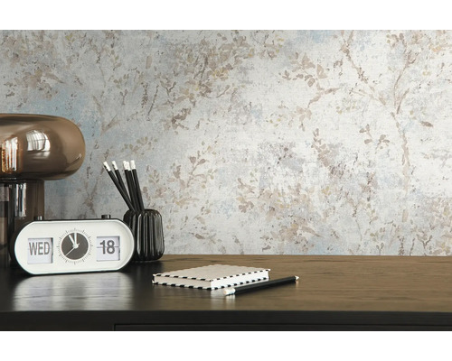 Scen med mönstrad tapet, bordslampa, kalender, anteckningsbok, pennhållare och pennor på ett skrivbord