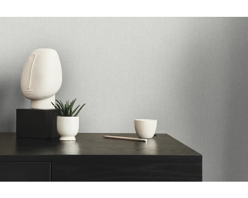 Närbild av en strukturerad tapet med minimalistisk dekoration på en mörk träbyrå.