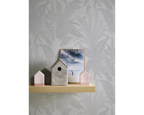 Dekorativt stilleben med blommig tapet, trähylla och prydnadshus