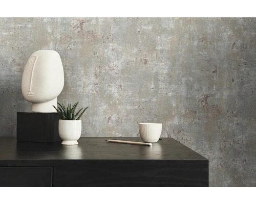 Närbild av en grå betongstruktur tapet med minimalistisk dekoration på en svart skänk.