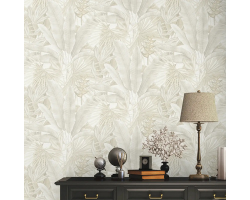 Närbild av en vardagsrumsvägg med tropisk bladstapeter och en byrå