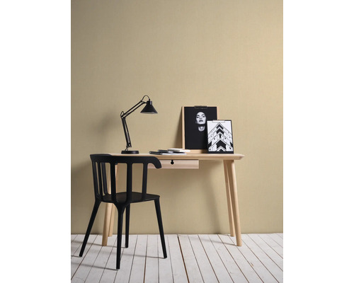 Skrivbord med lampa, anteckningsblock, penna, stol och fotoramar
