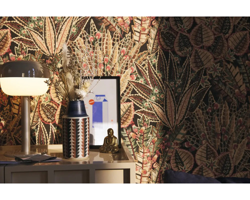 Dekorativt rum med mönstrad tapet, lampa, vas med torkade blommor och Buddha-figur