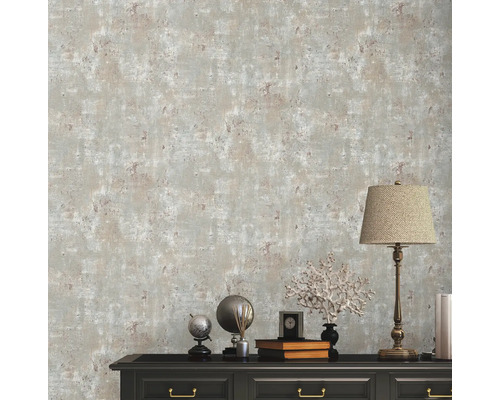 Scen med mönstrad tapet och byrå med dekorativa element och lampa