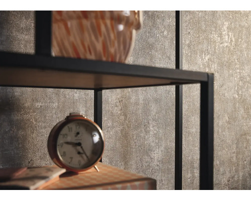 Dekorativa föremål på en svart metallhylla framför en brun vägg