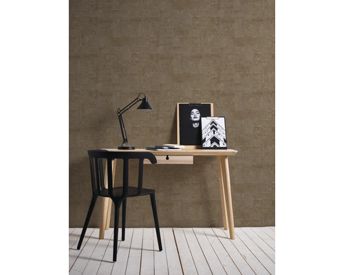 Arbetsrum med skrivbord, stol, lampa och dekoration framför en mönstrad vägg