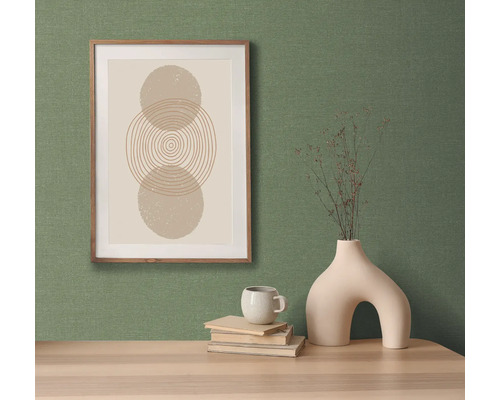 Dekorativt stilleben med en bild, en vas och en kopp på ett bord.