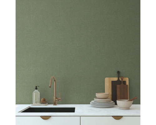 Köksscen med diskho, kran, disk och grön vägg