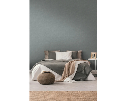 Sovrum med säng framför en strukturerad tapet