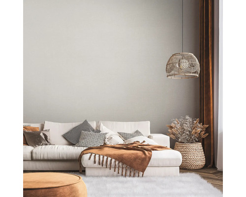 Vardagsrum med soffa, kuddar, pläd, lampa och dekoration i en ljus, mysig stil.