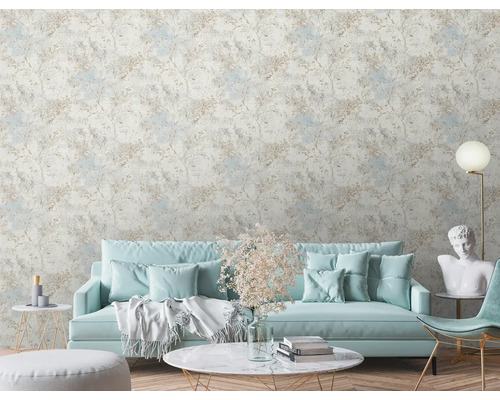 Vardagsrum med mönstrad tapet, soffa, bord och dekorationer.