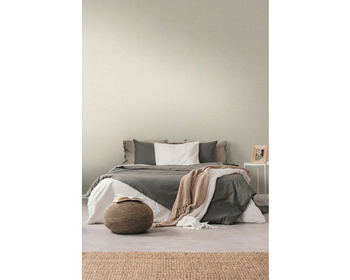 Sovrum med säng och diskret mönstrad tapet